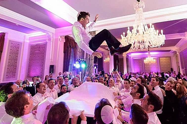 Man at wedding being bounced from cloth